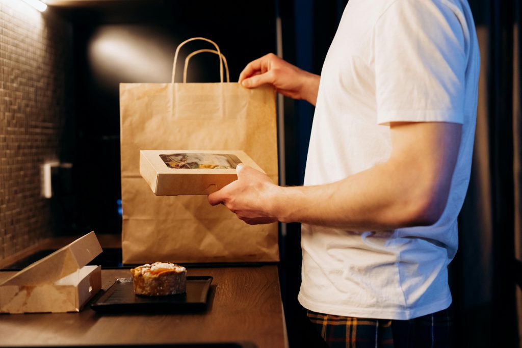 pexels-photo-6969973-6969973 Man unpacking a food delivery bag in a modern kitchen. Ideal for lifestyle or delivery themes.